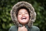 Child laughing with winter coat