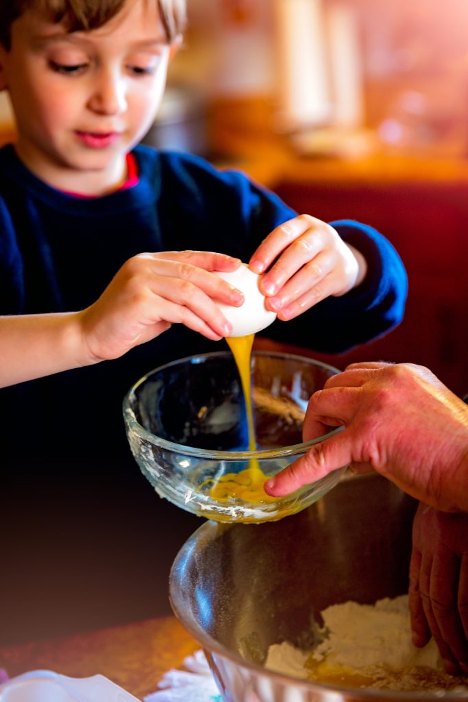 baking child breaking eggs